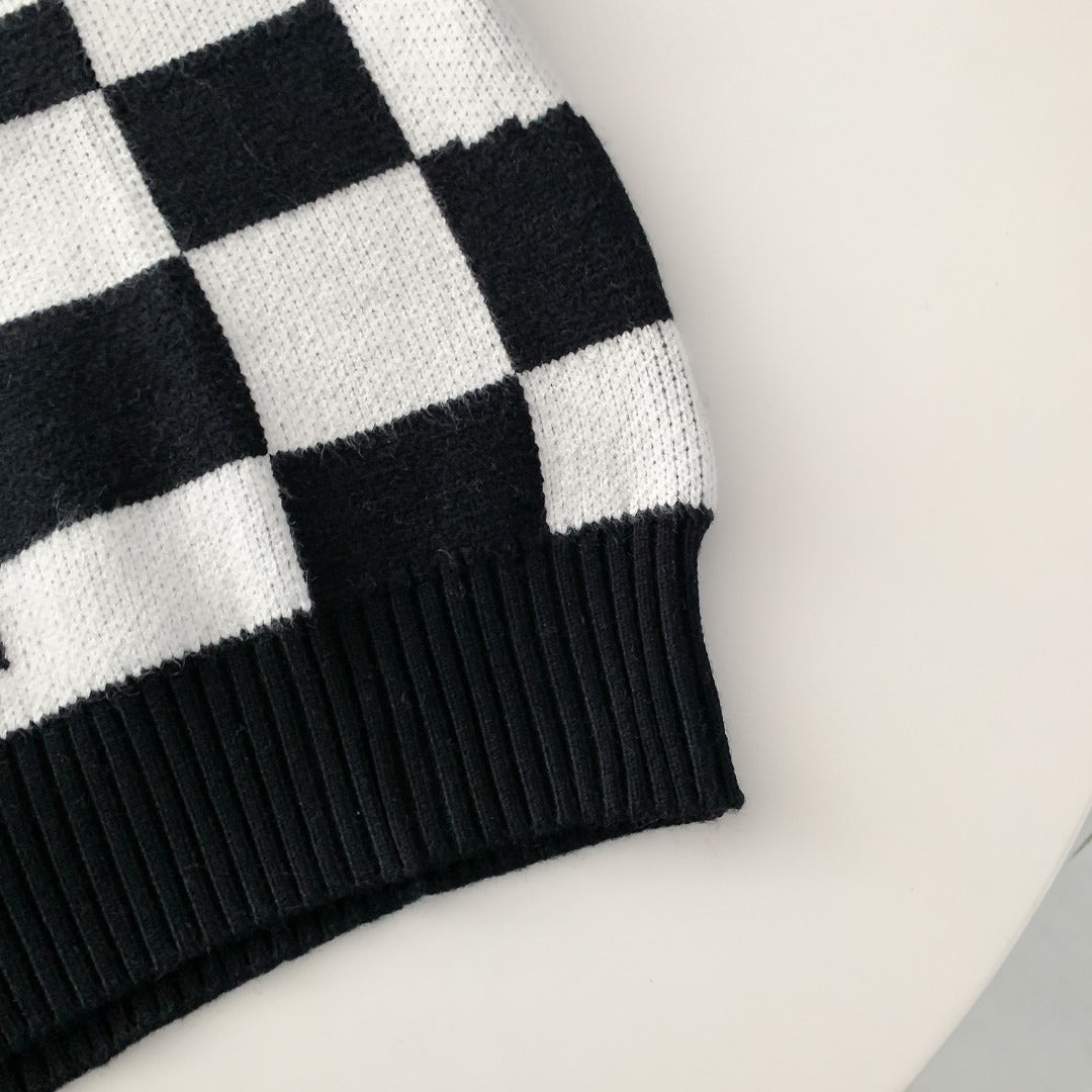 Irregular twisted black and white checkerboard turtleneck sweater